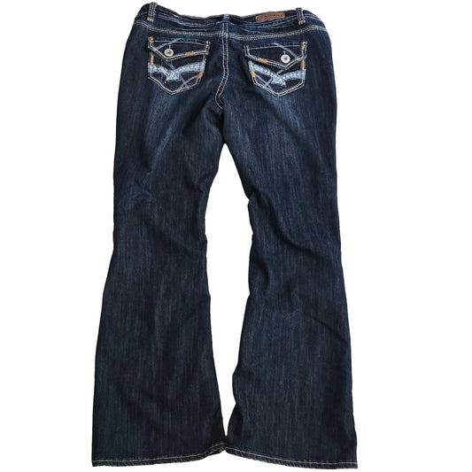 Folded pair of dark blue jeans on a beige carpet