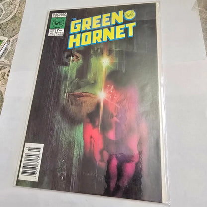 Comic book cover of 'The Green Hornet' with a green superhero and a woman holding a gun.