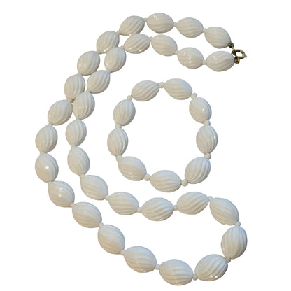 White beaded necklace on a light gray background