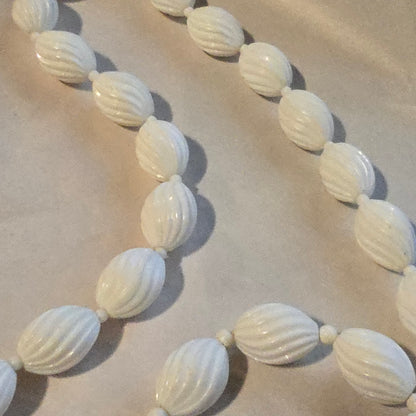 White beaded necklace on a beige background