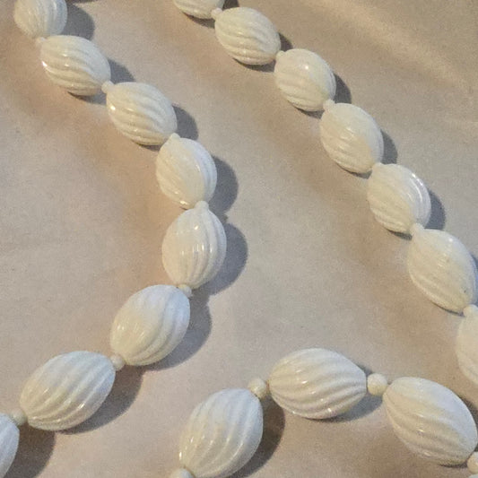 White beaded necklace on a beige background