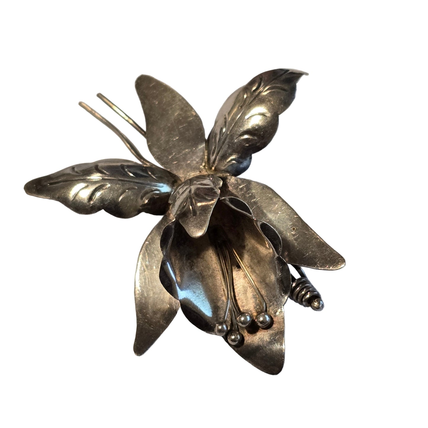 Silver flower-shaped brooch on a light gray background