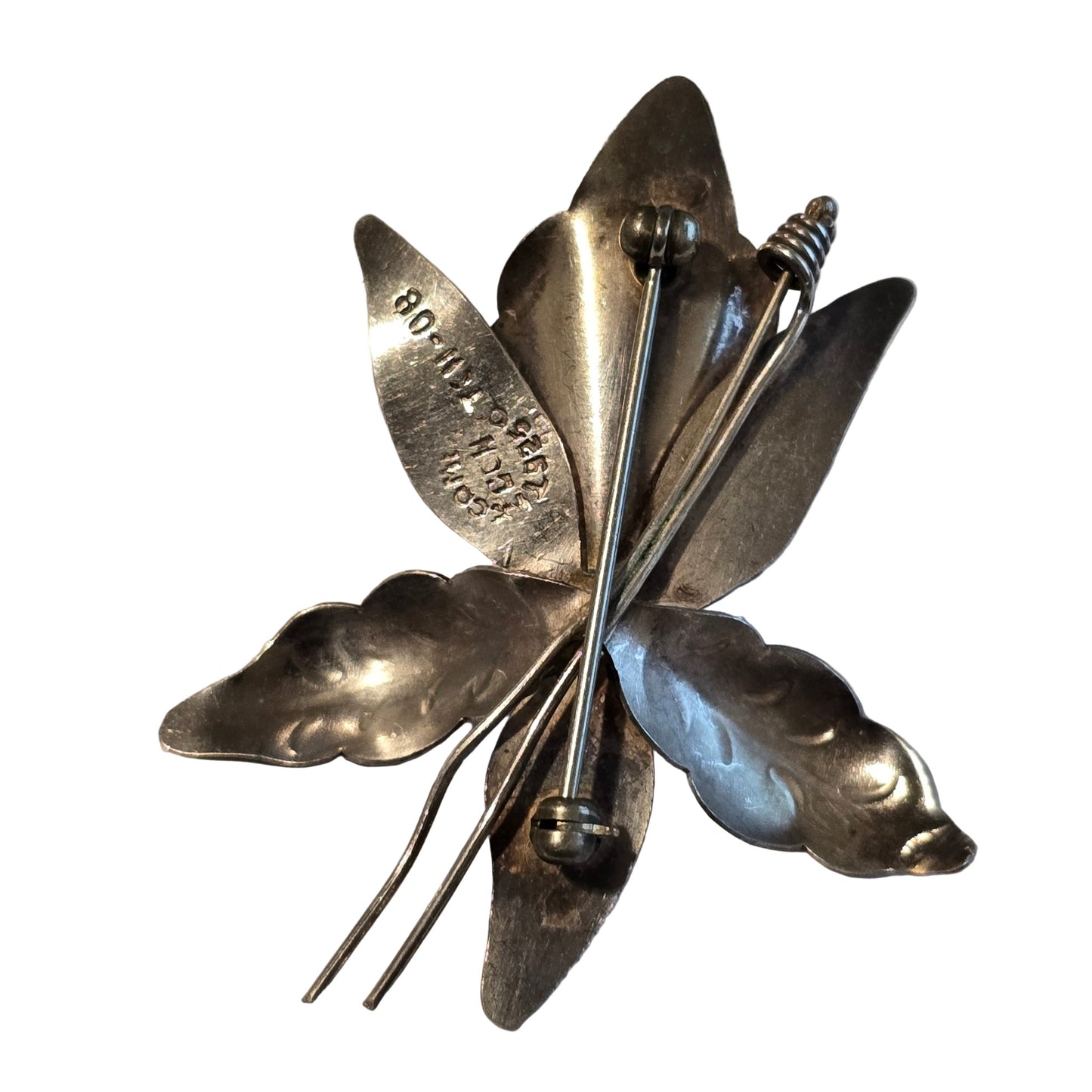 Silver butterfly brooch on a light gray background