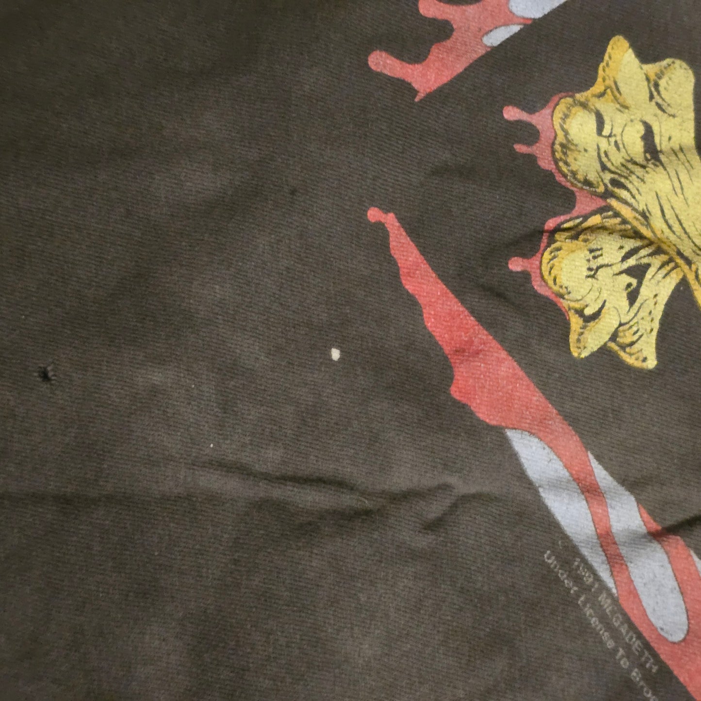Close-up of a dark fabric with a floral design and red and white abstract elements.