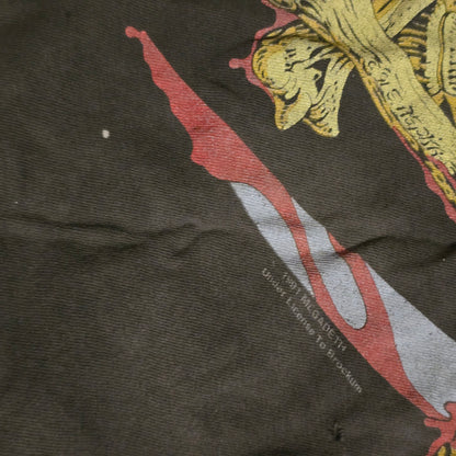 Close-up of a dark fabric with embroidered designs, including a red and white stripe and gold floral pattern.