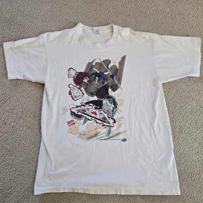 White t-shirt with colorful graphic design on a beige carpet