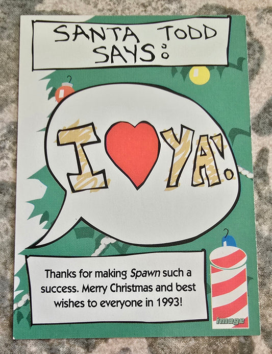 Handmade card with 'Santa Todd Says' text and a heart graphic on a textured surface.