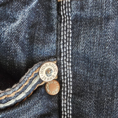 Close-up of a button on a pair of jeans with 'RRL' branding.