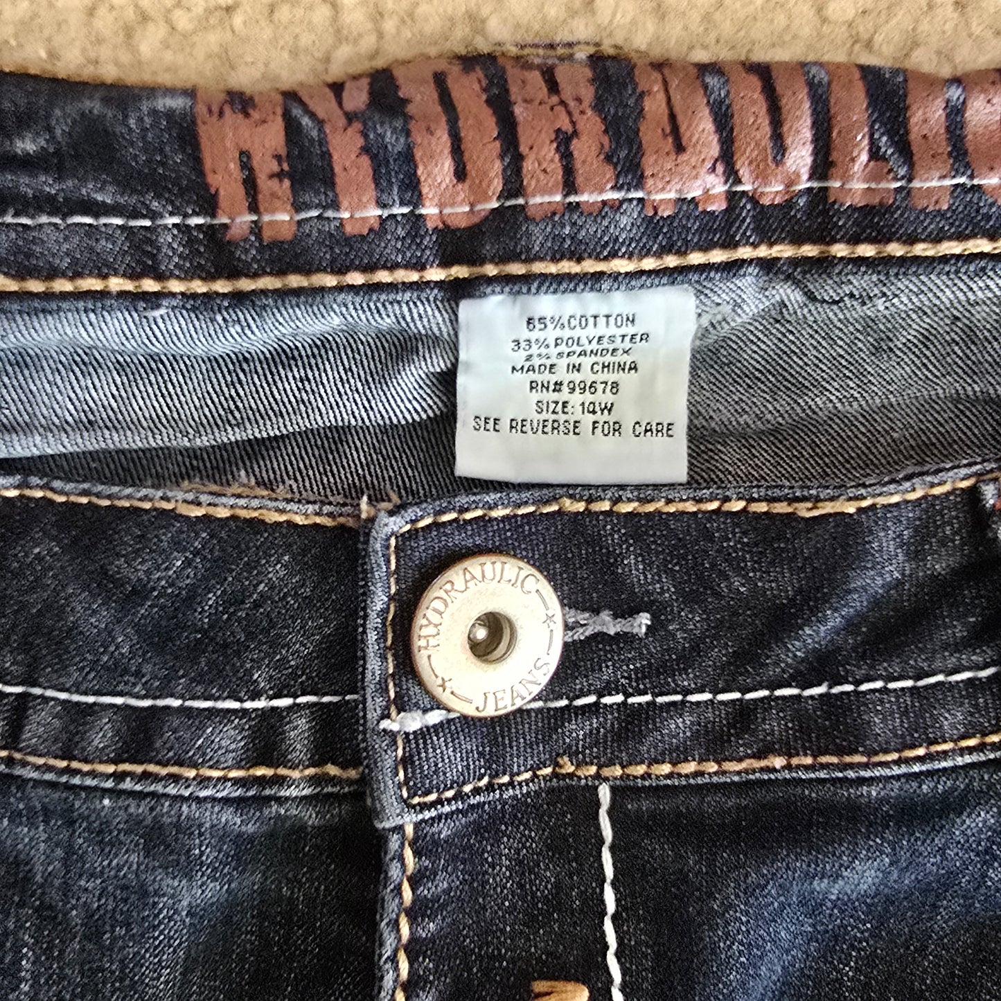 Close-up of a denim jacket with a brand label and button.