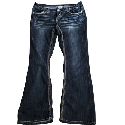 Pair of dark blue jeans laid flat on a beige surface