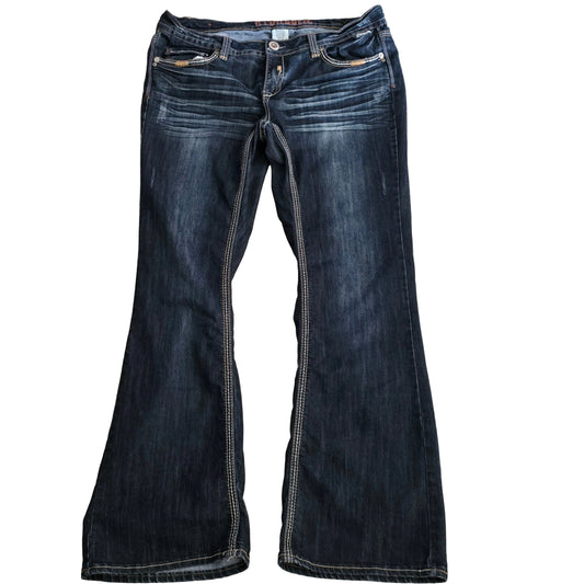 Pair of dark blue jeans laid flat on a beige surface