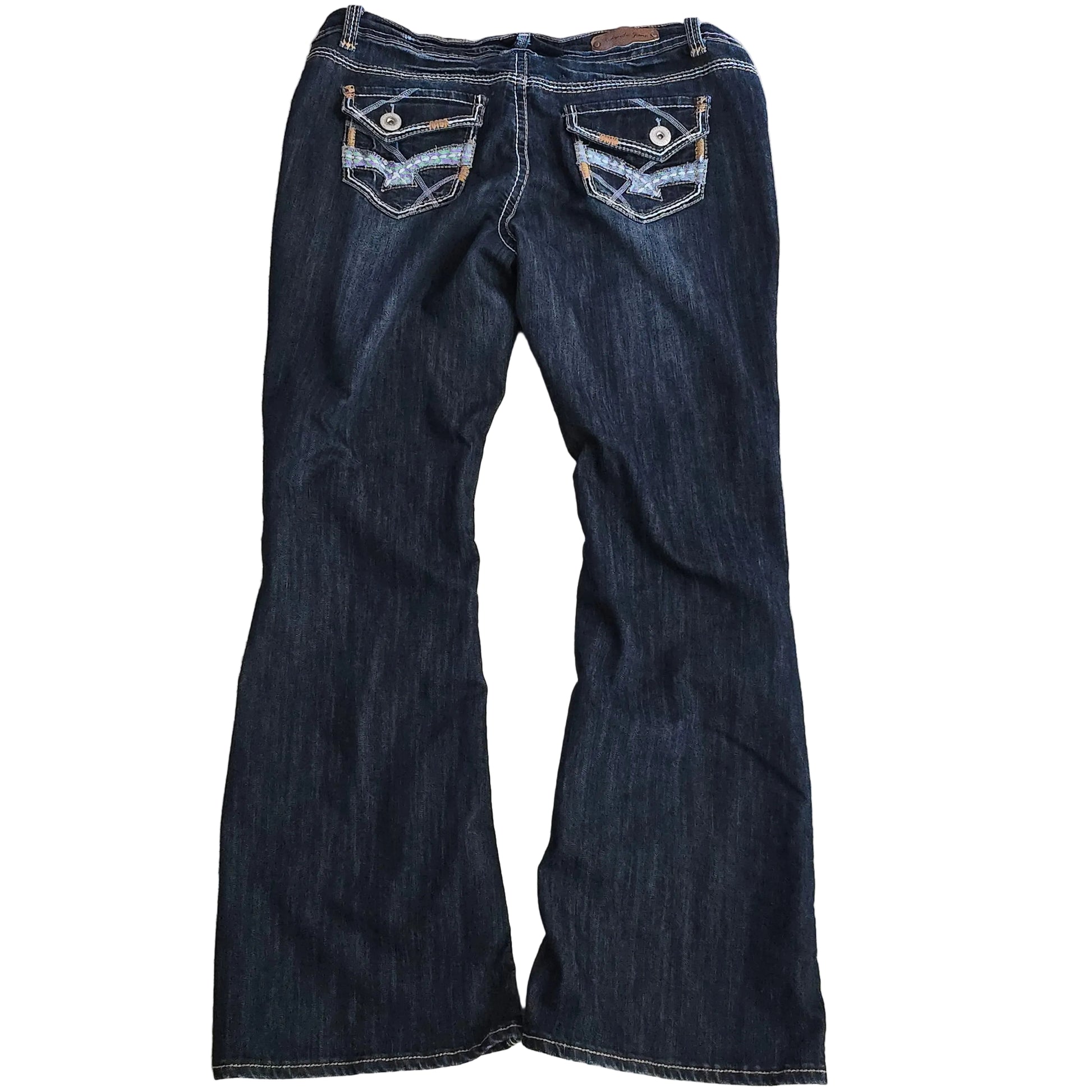 Folded pair of dark blue jeans on a beige carpet