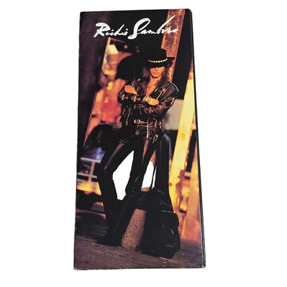 Product packaging with a person wearing black shoes on a carpeted floor